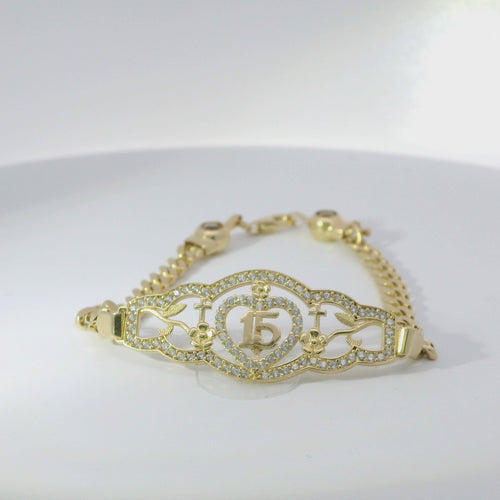 14KT Gold Bracelet Women's "15" Quinceanera Plaque with Heart Center and Plain Cross and Rose Sides with White CZ Stones Border and White CZ Stone End Cuban Link Lobster Clasp